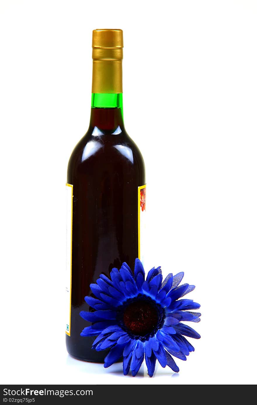 Grape wine botttle with gerbera flower isolated on white background.