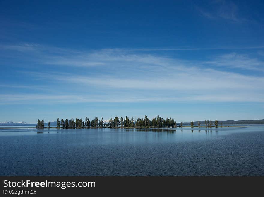 Row of pines stretching across Yellowstone Lake in Yellowstone National Park, northern Wyoming. Row of pines stretching across Yellowstone Lake in Yellowstone National Park, northern Wyoming.