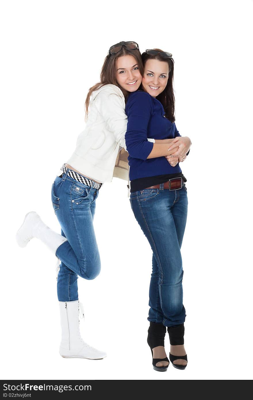 Two girls friends in jeans isolated on white