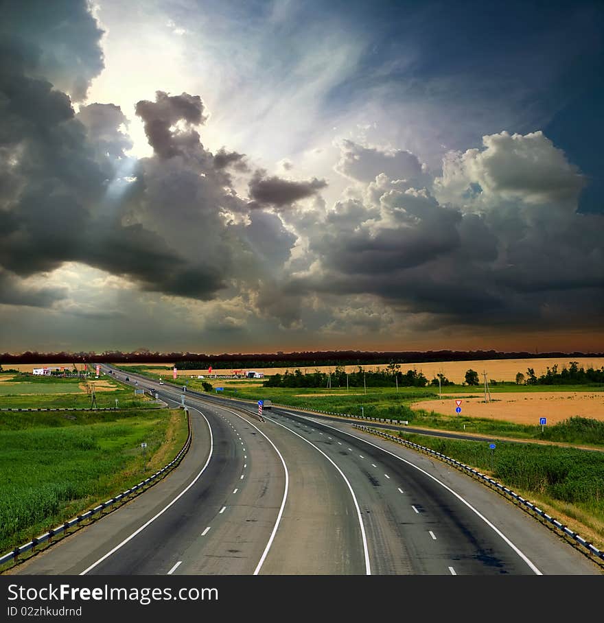 Asphalt road with a fence against the blue sky