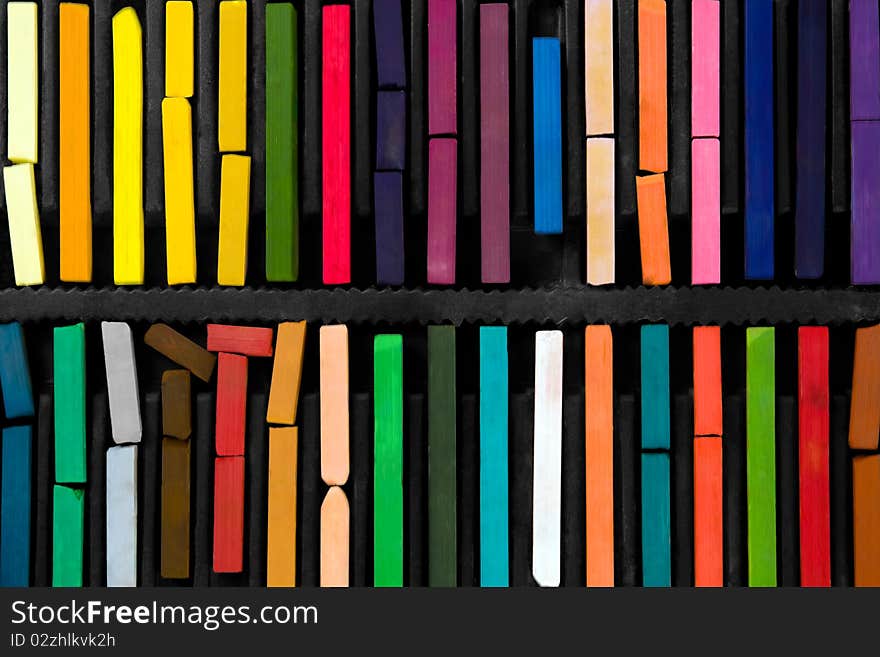 Bars of bright and colorful pastel on black background