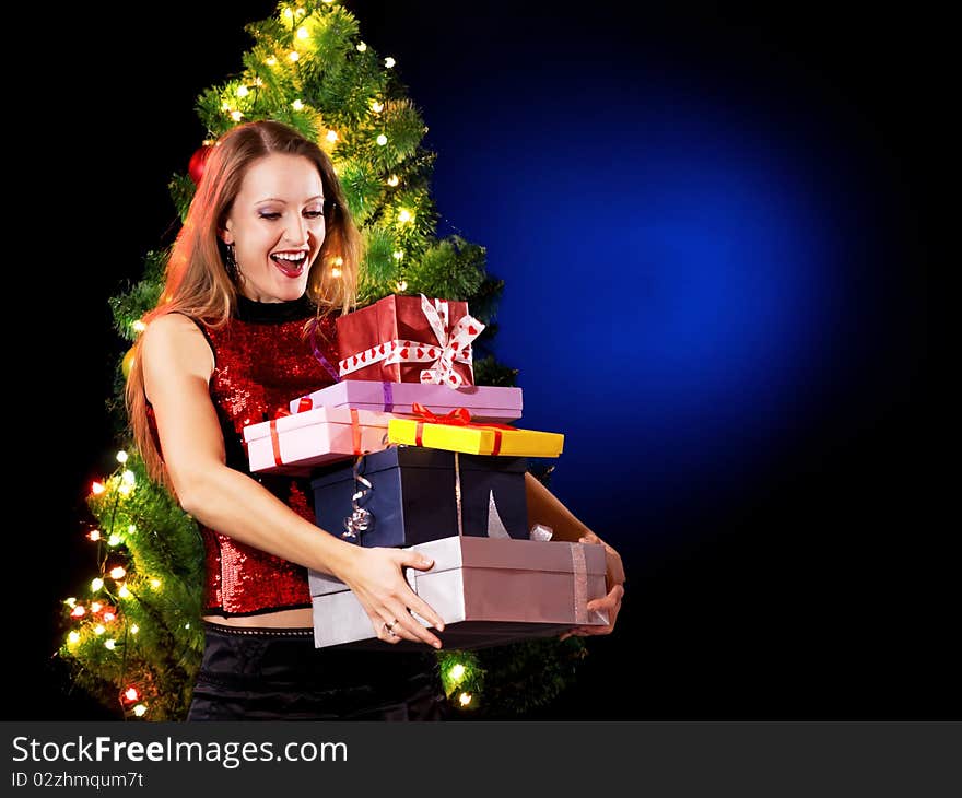 Christmas woman with a gift in her hands near a Christmas tree