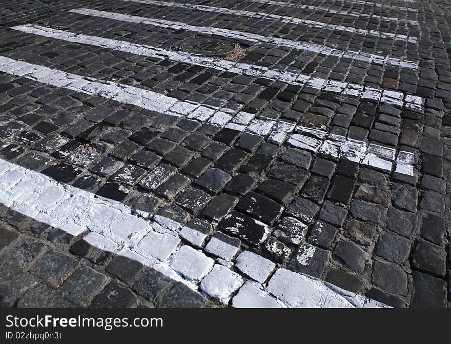 Paving stones texture with painted white pedestrian crossing