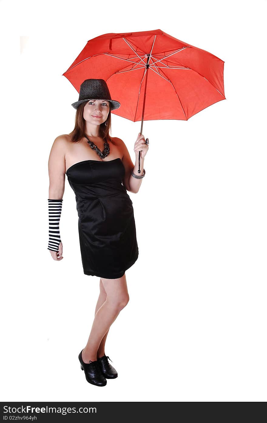 An middle aged woman in an short black dress and a gray hat standing in the studio with a red umbrella in her hand. An middle aged woman in an short black dress and a gray hat standing in the studio with a red umbrella in her hand.