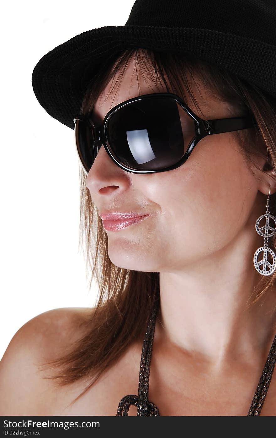 A closeup portrait of a middle aged woman with a black hat and big sunglasses a nice necklace and earrings, in profile. A closeup portrait of a middle aged woman with a black hat and big sunglasses a nice necklace and earrings, in profile.