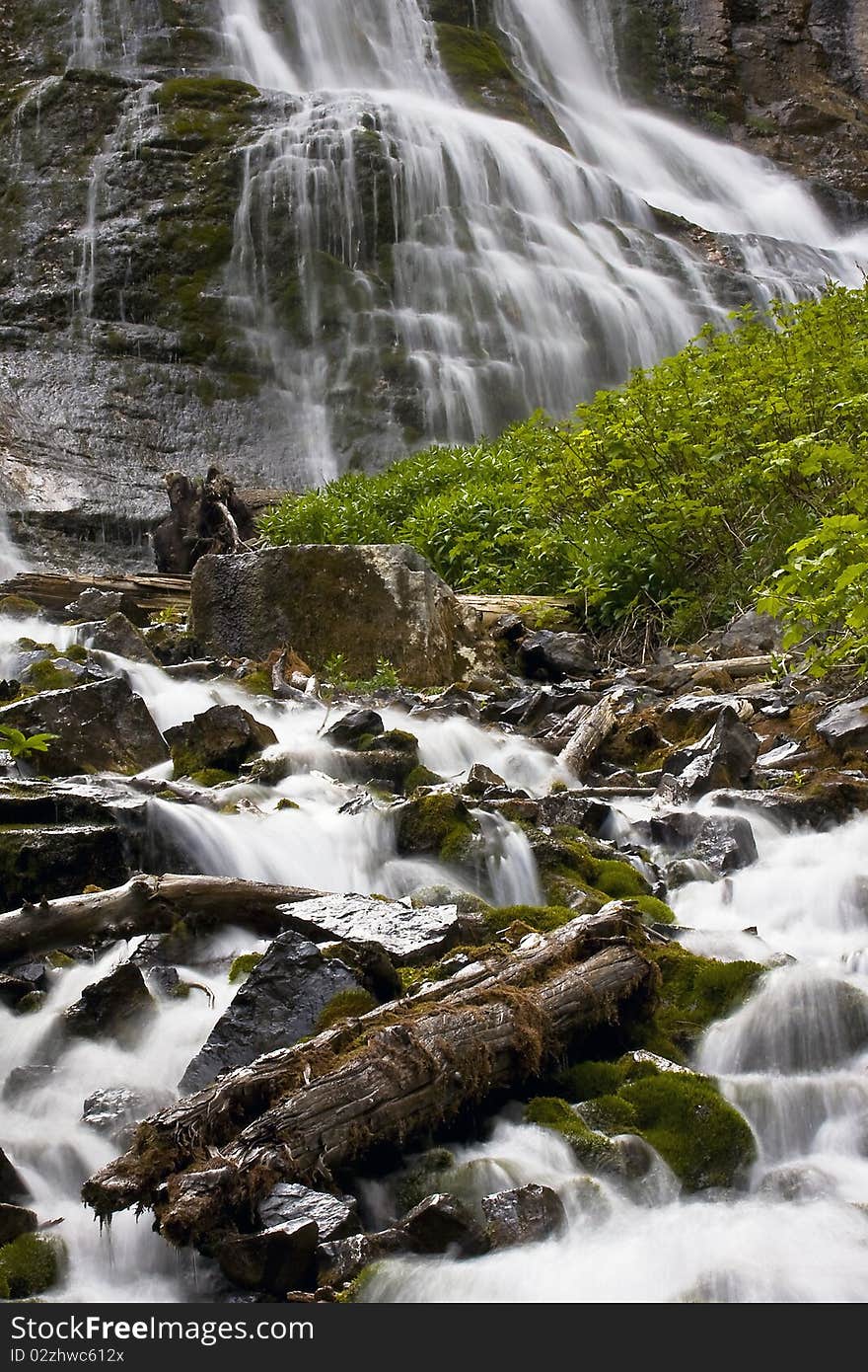 Mountain waterfall and stream with moss covered rocks