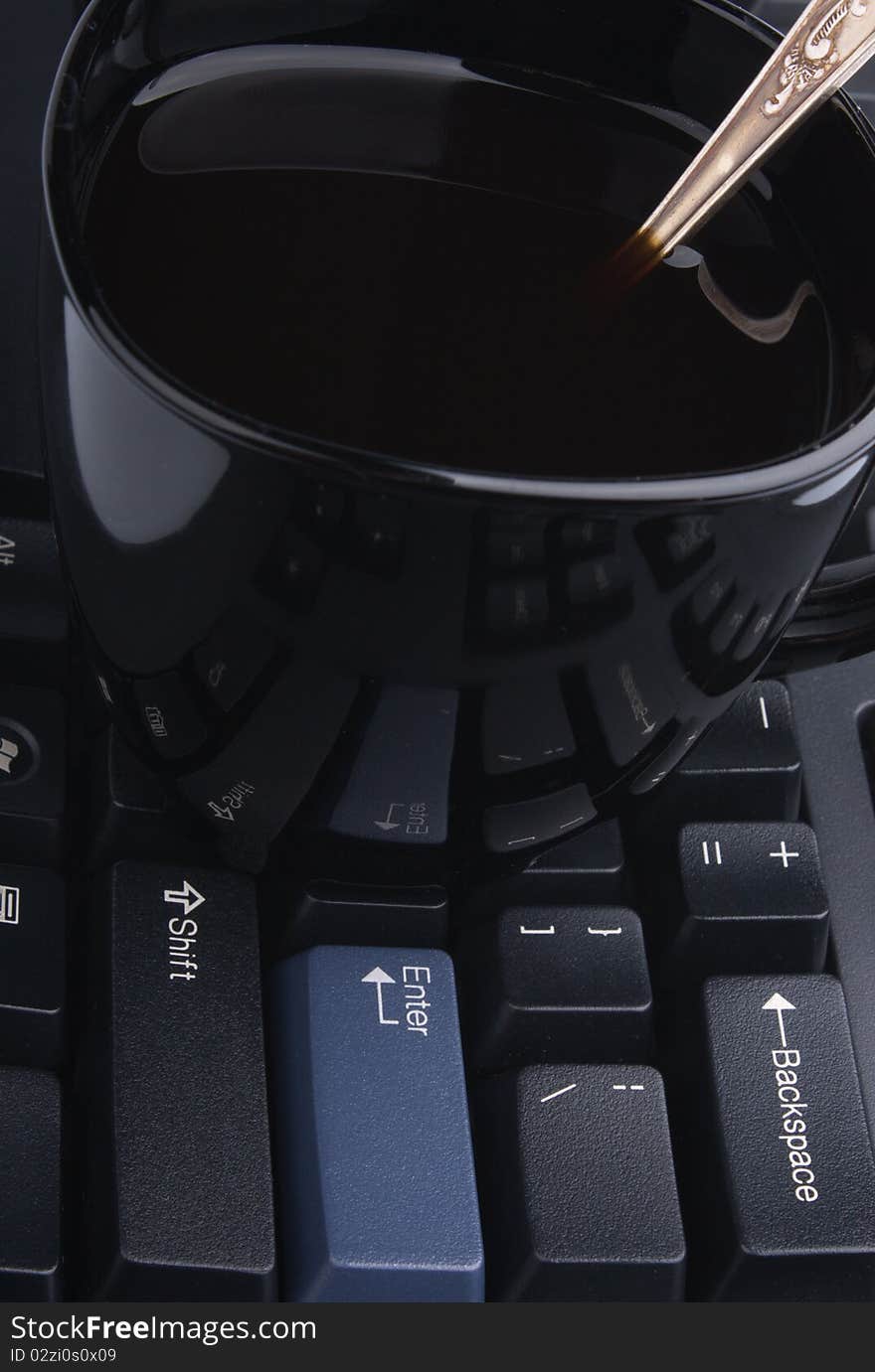 Black cup of coffee on a computer keyboard, contept of business still-life. Black cup of coffee on a computer keyboard, contept of business still-life