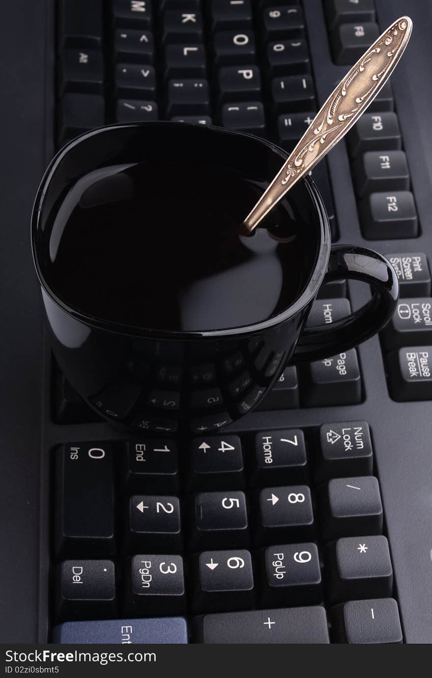 Cup Of Coffee On A Computer Keyboard