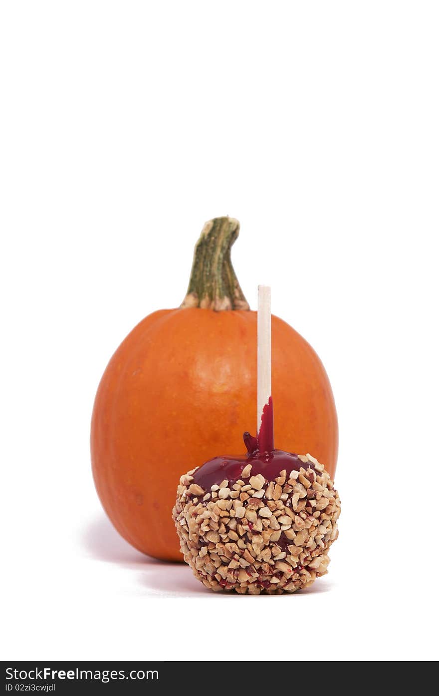 A Candy Apple and Small Pumpkin Isolated against a White Background. A Candy Apple and Small Pumpkin Isolated against a White Background