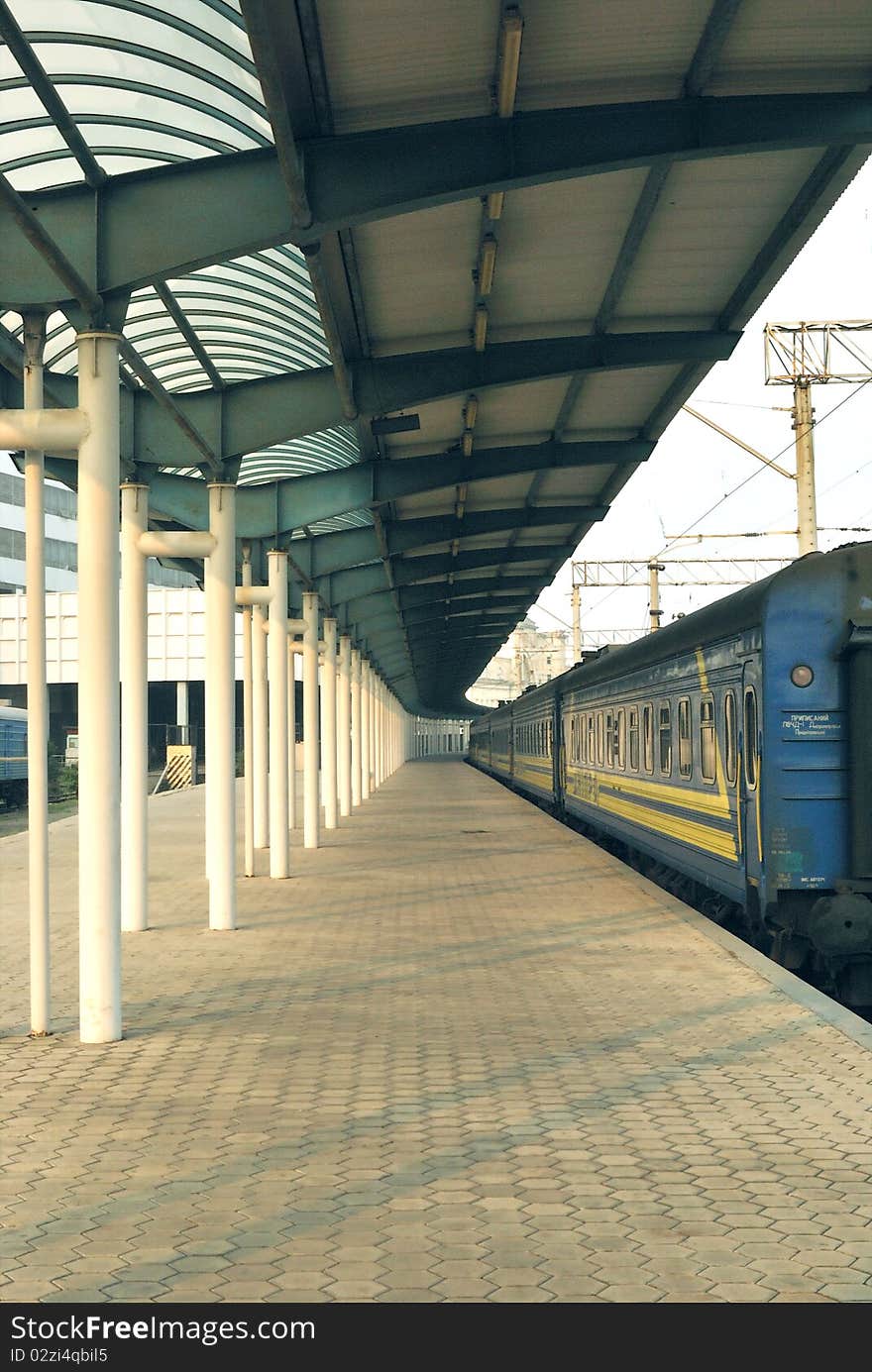 It is early morning at the railway station when there are no peoples at the platform. The passenger train waits the hour of departure. This shoot is made in one of the Ukrainian towns. It is early morning at the railway station when there are no peoples at the platform. The passenger train waits the hour of departure. This shoot is made in one of the Ukrainian towns.