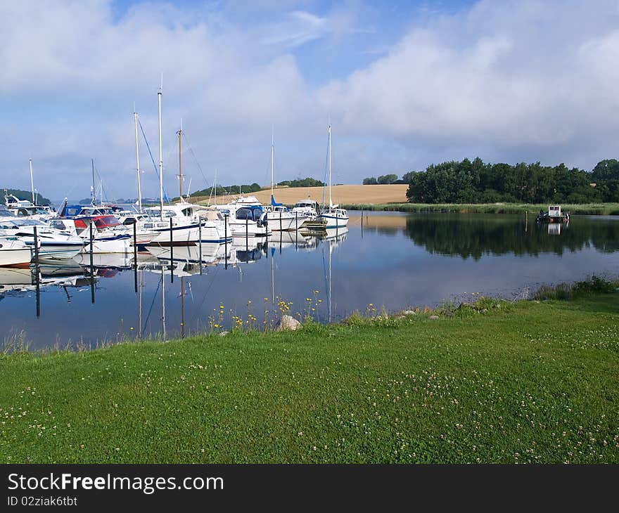 Yachts and sail boats moored to docks in a marina - sailing background image. Yachts and sail boats moored to docks in a marina - sailing background image