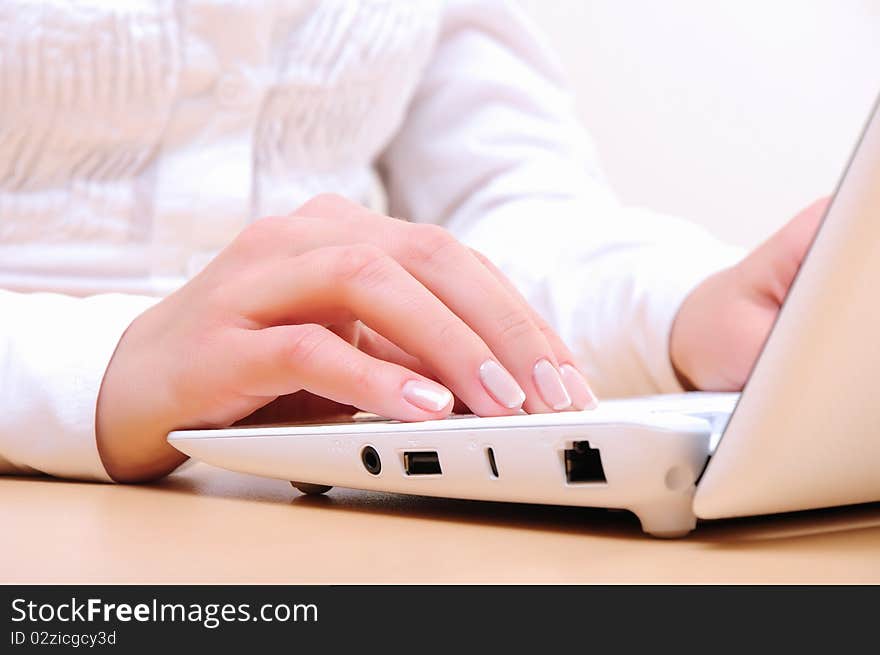 Hands of a young girl running on a computer in the office.