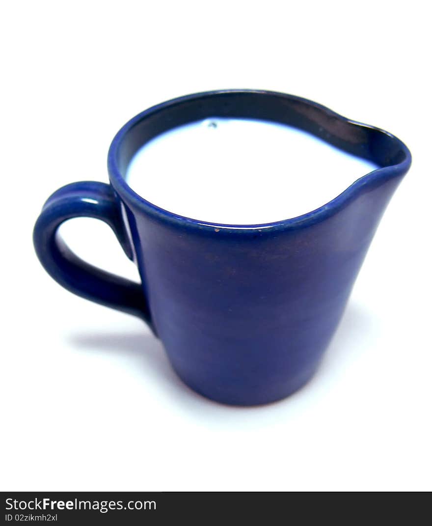 A blue ceramic jug with wilk on a white background. A blue ceramic jug with wilk on a white background.