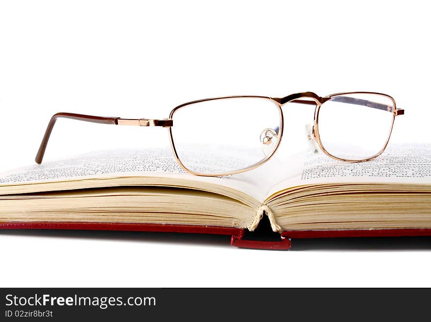 Book and glasses isolated on white background