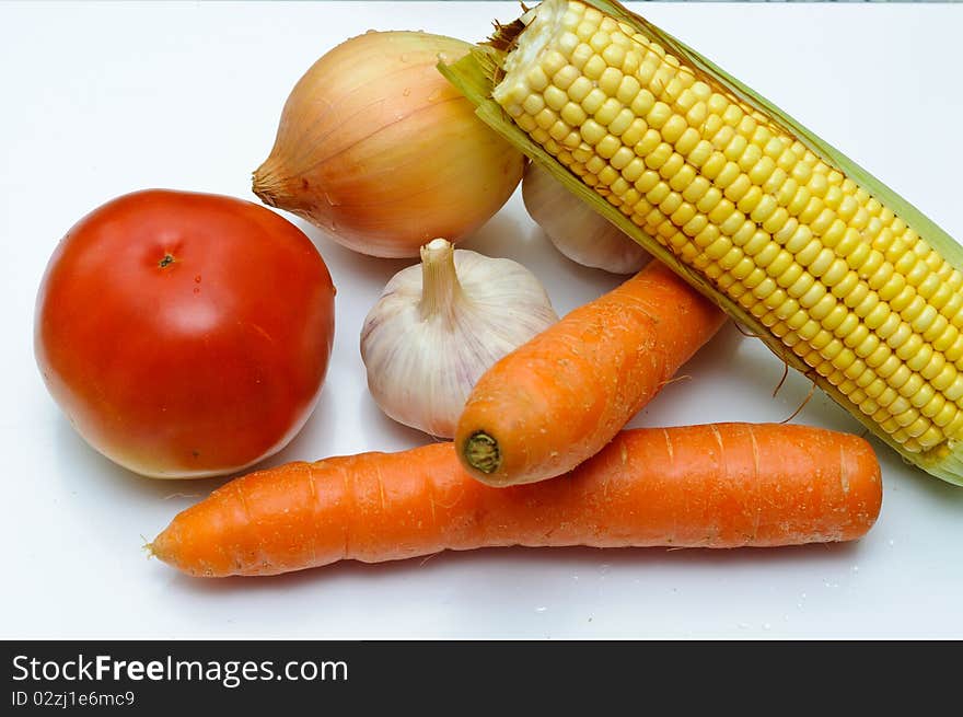 Fresh vegetables on a cut table. Tomato, onion, corn, garlic