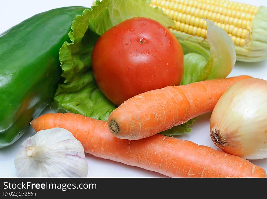 Fresh vegetables on a cut table. Tomato, onion, corn, garlic