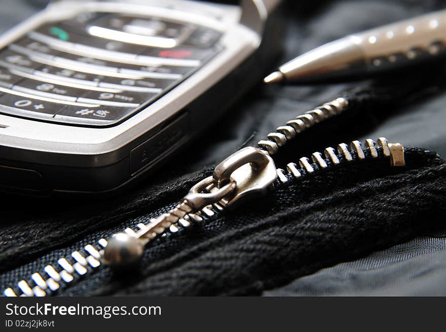 Cellphone and ballpoint on top of a briefcase. Cellphone and ballpoint on top of a briefcase