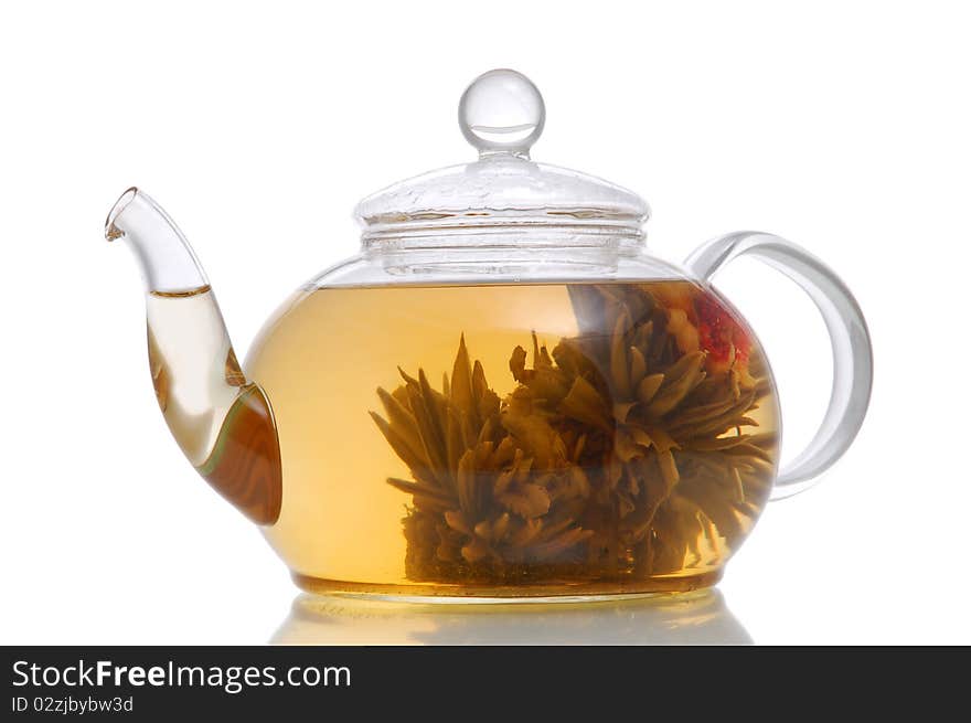 Glass teapot with blooming flower green tea on white background