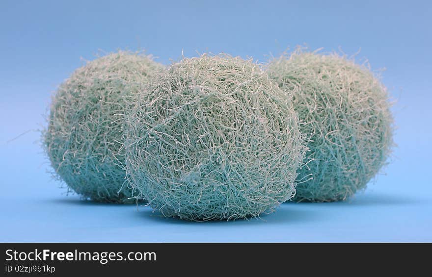 Three fluffy yarns against blue background