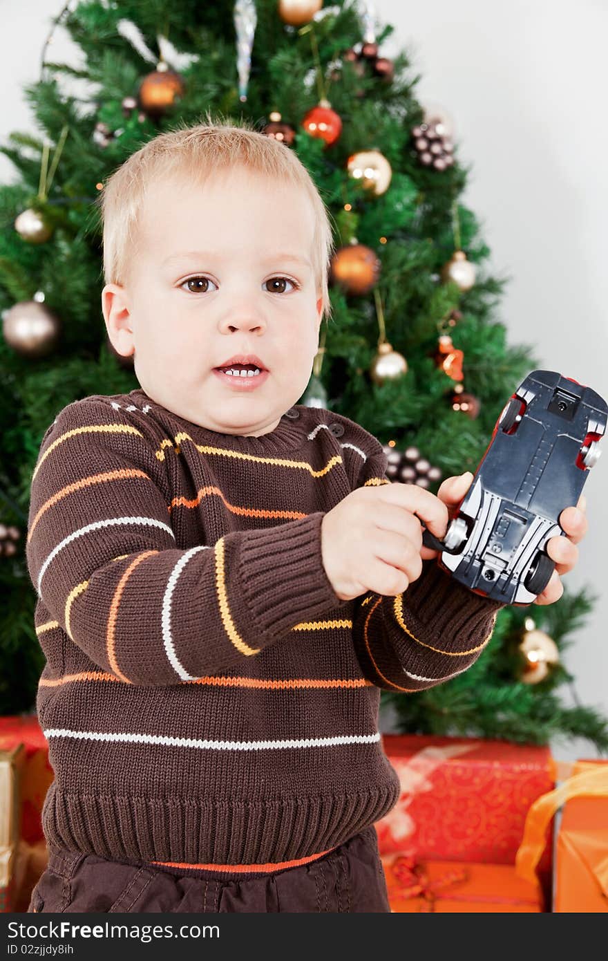 Baby boy playing with a toy car at christmas