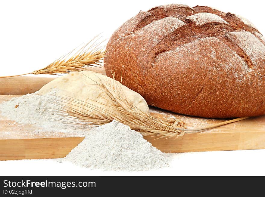 Still life with bread, dough, flour and rolling-pin on a wooden board. Still life with bread, dough, flour and rolling-pin on a wooden board