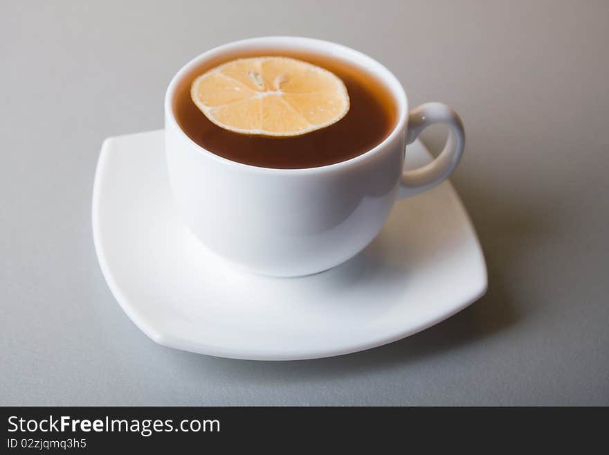 Cup of Tea with lemon slice on gray table