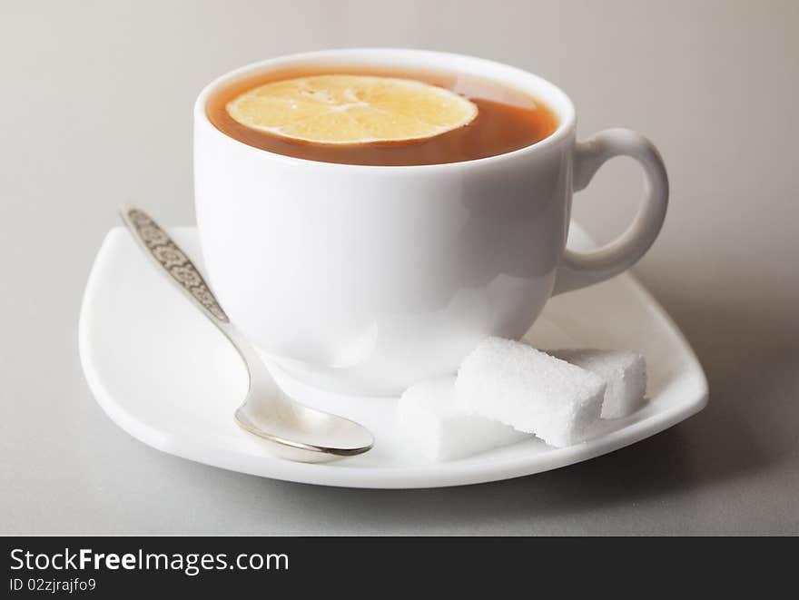 Cup of Tea with lemon slice and sugar on gray table