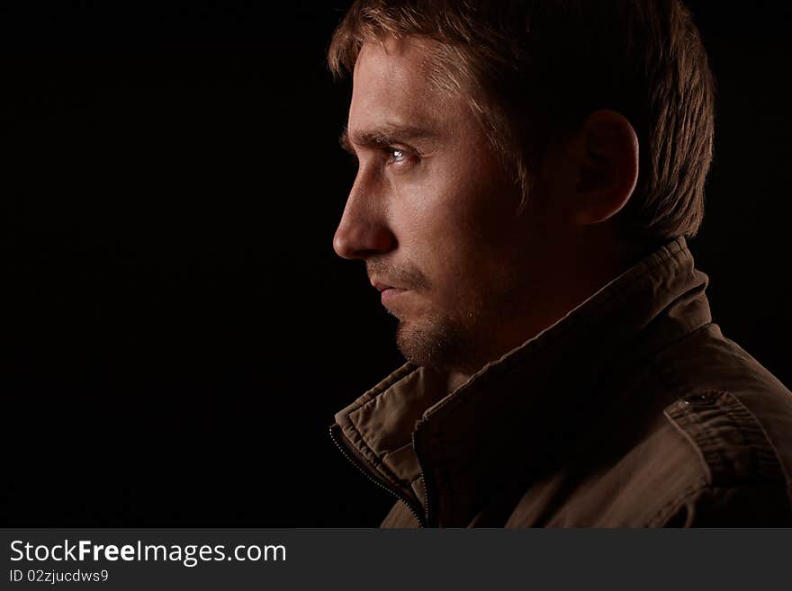 The portrait of young man on black background