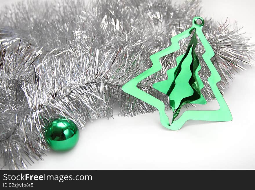 Christmas background with silver tinsel, green sphere and stylish cristmas tree decoration. Christmas background with silver tinsel, green sphere and stylish cristmas tree decoration