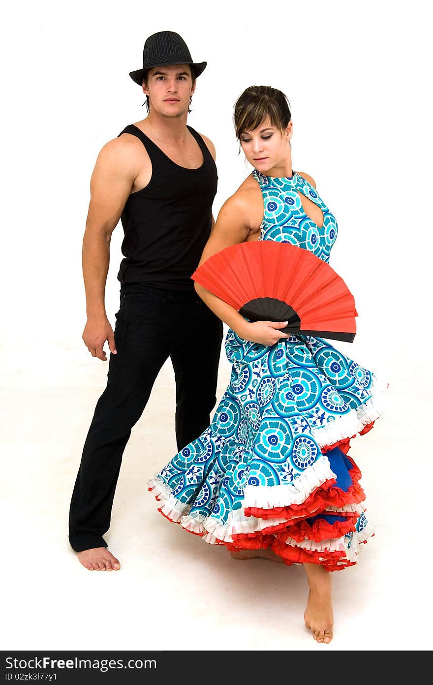 Young dancing couple posing wearing black red and blue clothing and female holding a red open Chinese fan. Young dancing couple posing wearing black red and blue clothing and female holding a red open Chinese fan