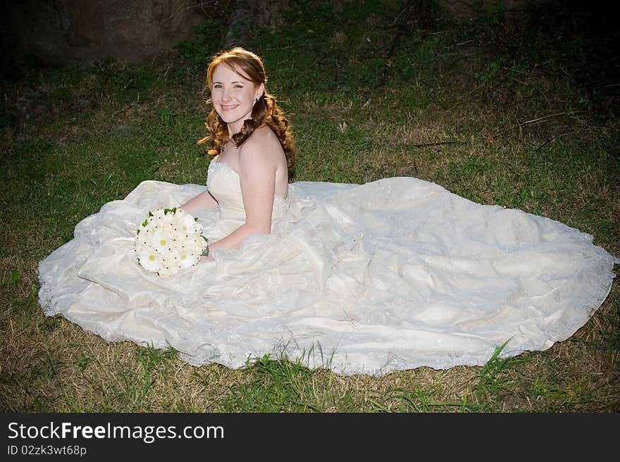 Sexy beautiful bride in white dress sitting