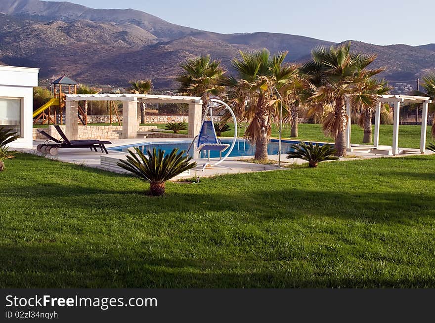 Swimming pool, sunbeds and palms at luxury villa, Crete, Greece. Swimming pool, sunbeds and palms at luxury villa, Crete, Greece