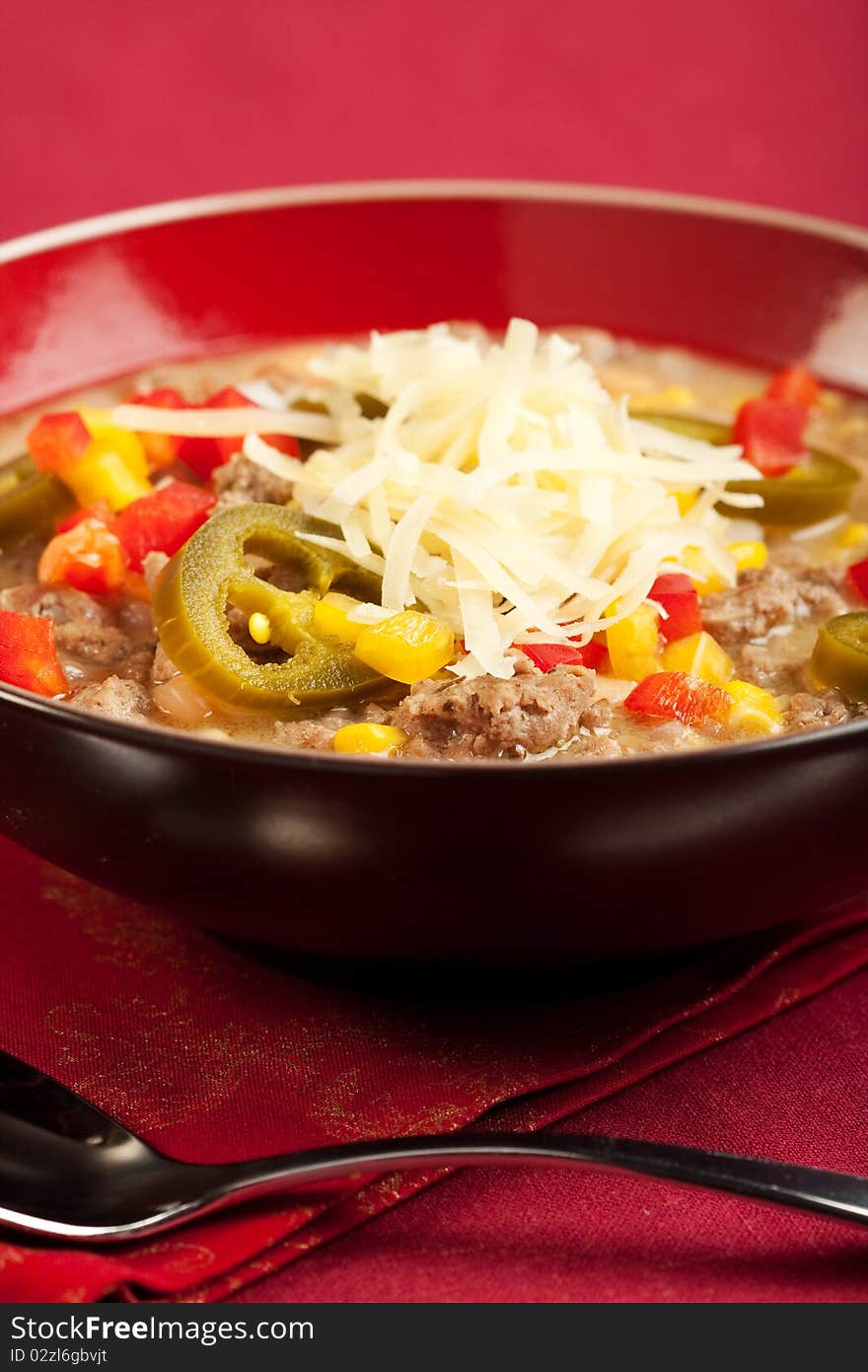 A turkey based white chili topped with cheese and peppers