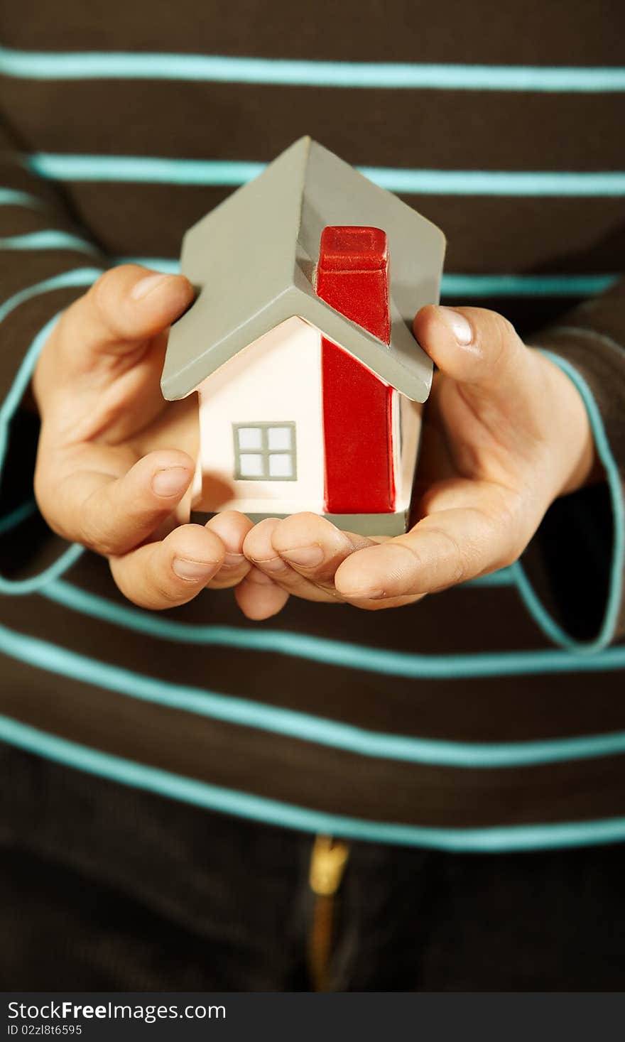 Close-up of kids hands holding a small house. Close-up of kids hands holding a small house