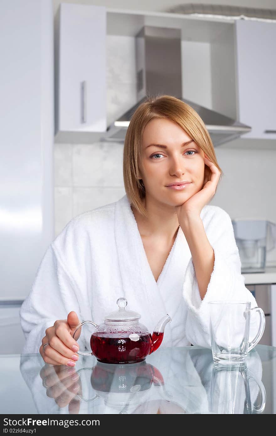 Beautiful young woman drinking tea at home in the morning