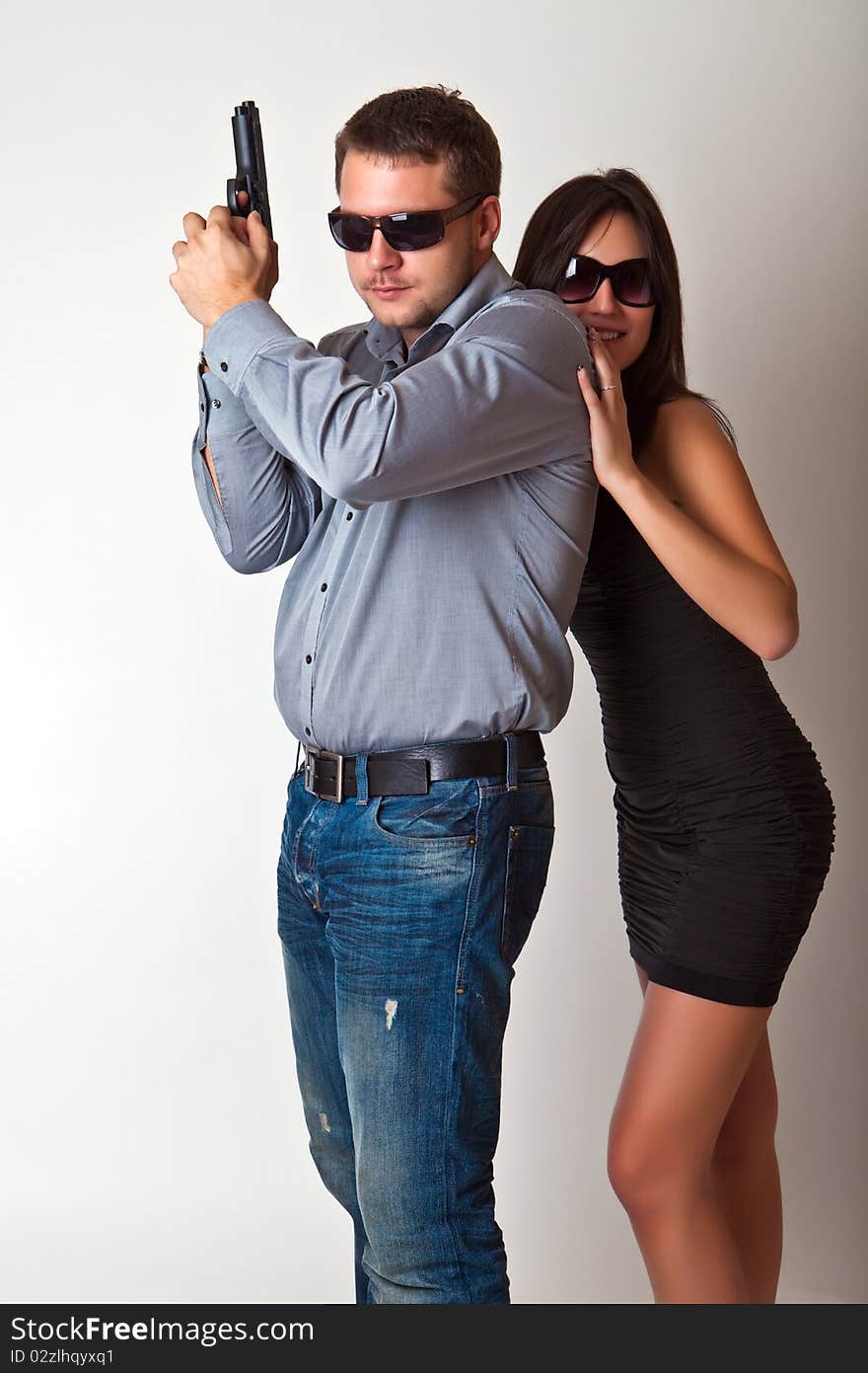 Man with a gun and the woman in sun glasses. Man with a gun and the woman in sun glasses