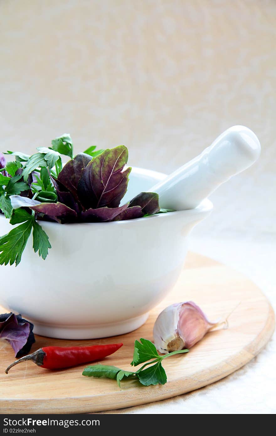 Mortar and pestle with herbs on a wooden board