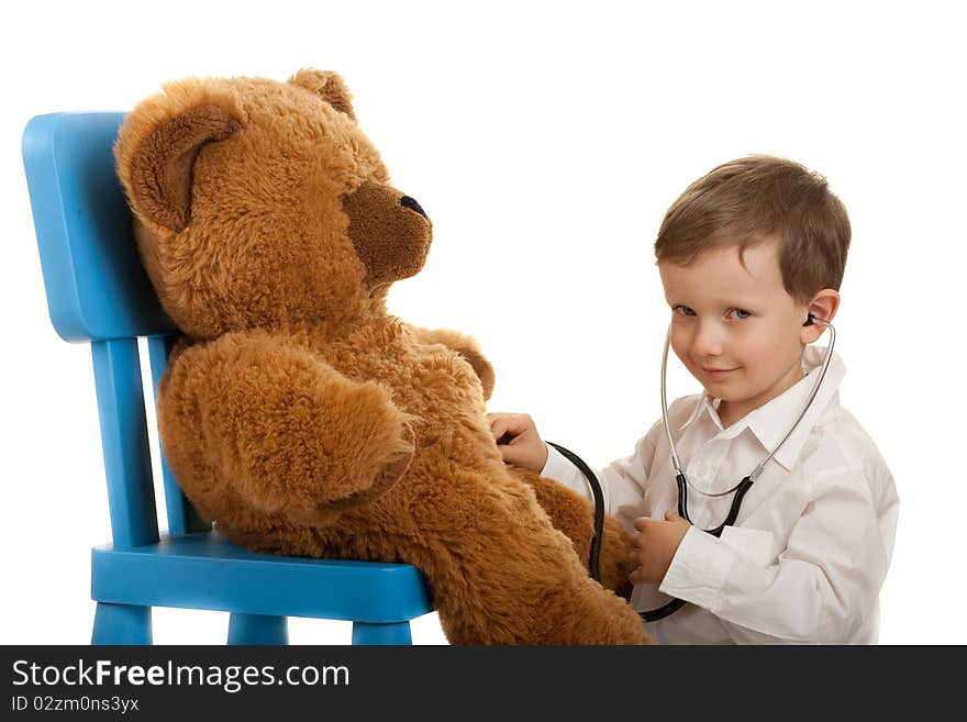 Child playing in doctor with stethoscope examination teddybear. Child playing in doctor with stethoscope examination teddybear.