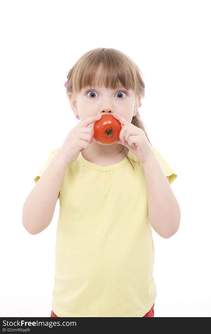 The portrait of a cute little girl holding a red tomato in her hands