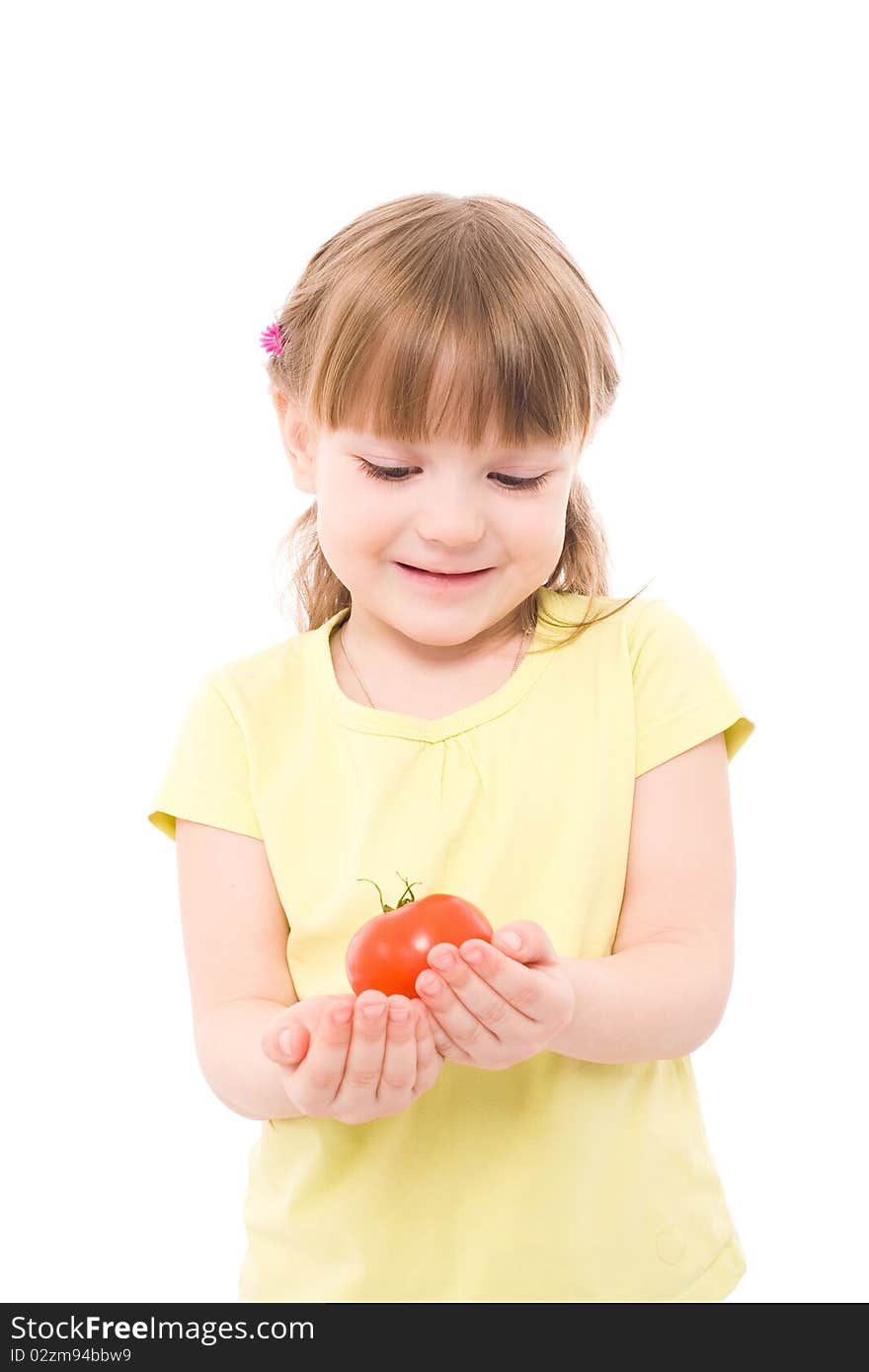 The portrait of a cute little girl holding a red tomato in her hands