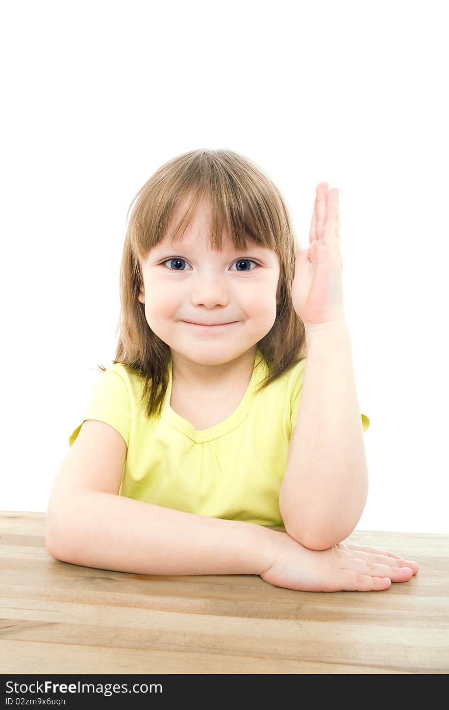 The portrait of a clever little girl sitting at the table