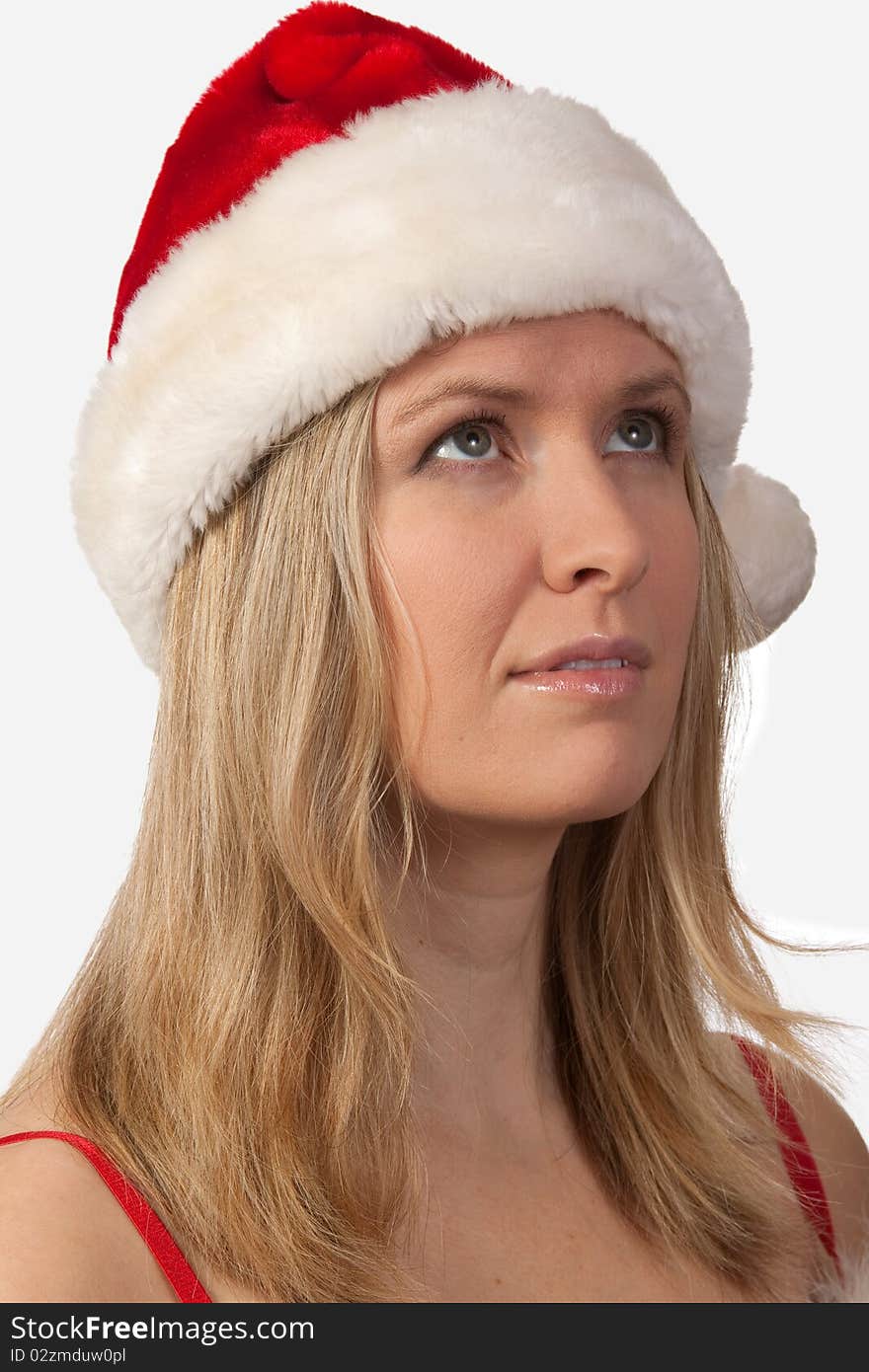 Portrait of an attractive blond woman wearing santa hat looking upwards. Portrait of an attractive blond woman wearing santa hat looking upwards