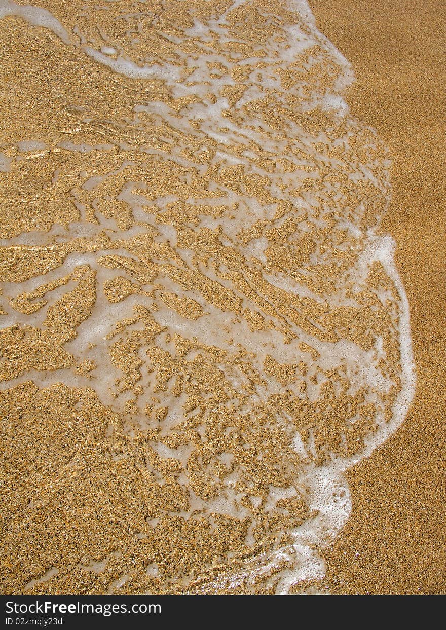 Wave of water on clear sandy beach