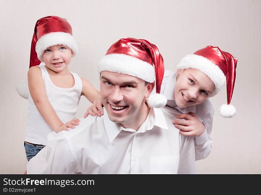 Happy and merry father and two sons in santa hat. Happy and merry father and two sons in santa hat