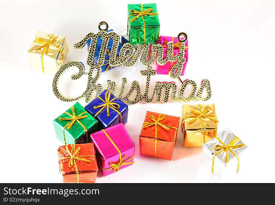 Colorful wrapped gift with a board written merry christmas. Colorful wrapped gift with a board written merry christmas