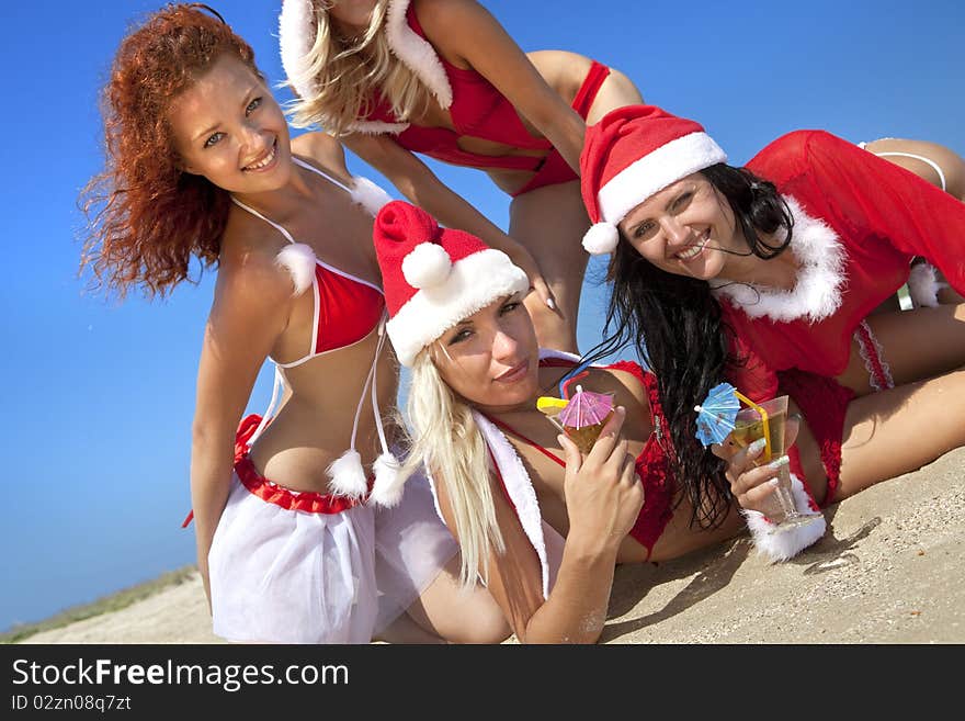 Women in christmas suit with martini on the beach