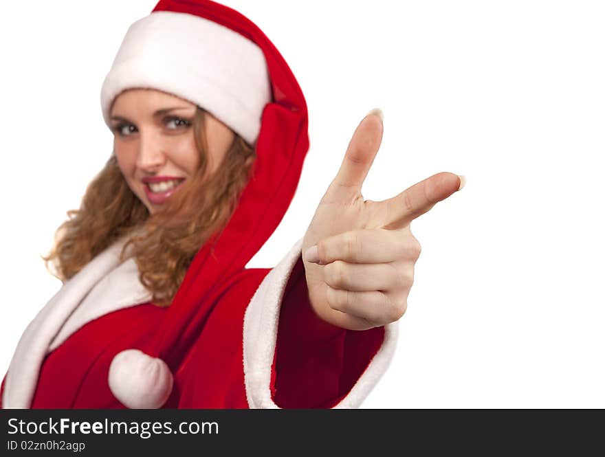 Dancing girl in santa suit is pointing her finger at the camera and looking with a smile. Isolated on white.