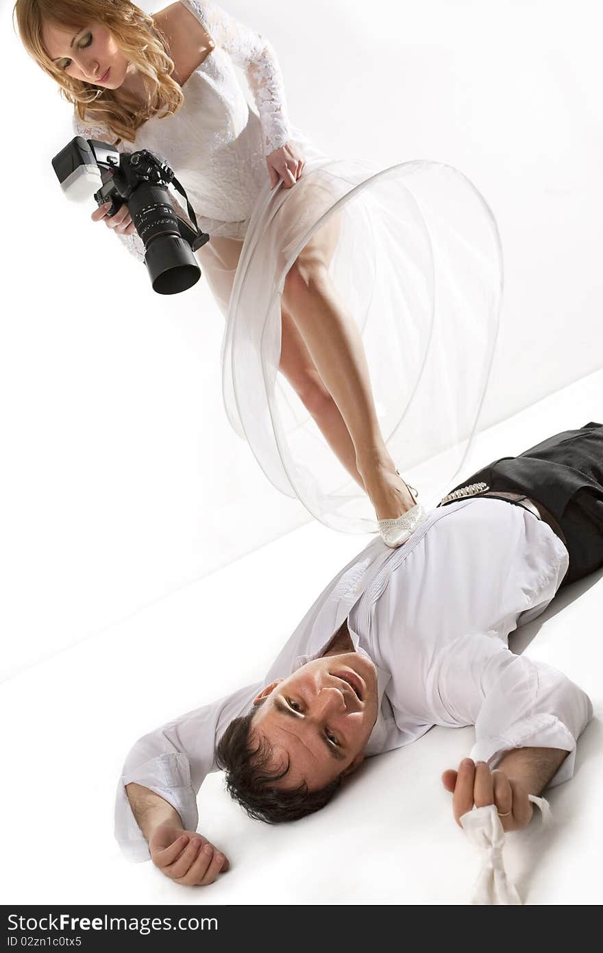 Bride taking picture of her groom laying on floor