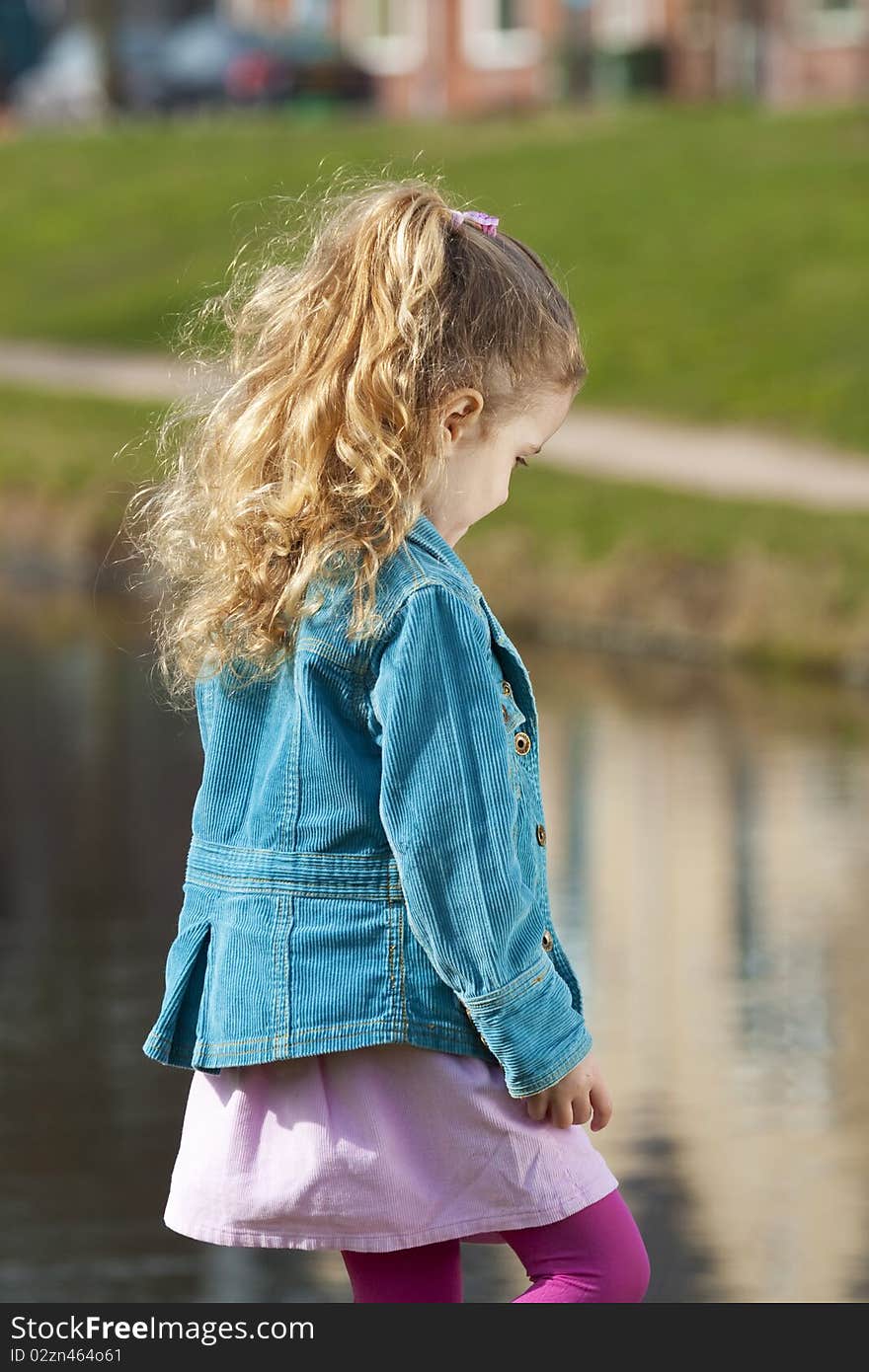 Back view of a little girl looking at river. Back view of a little girl looking at river.