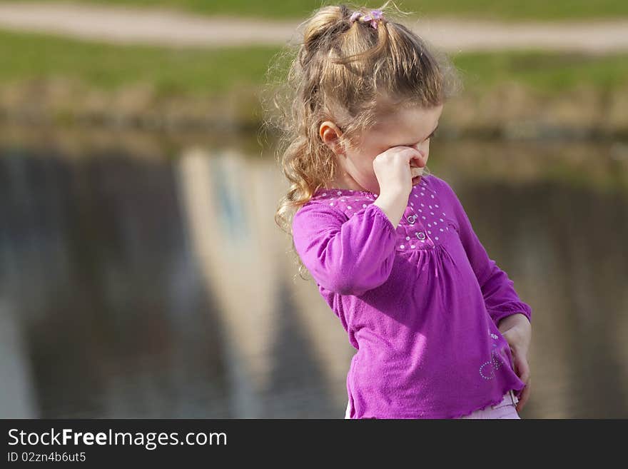 Crying girl ashore river.